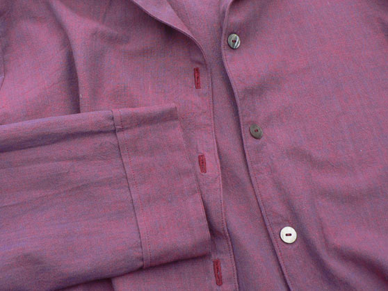 Buttonholes, buttons and sleeve cuff of purple nightshirt